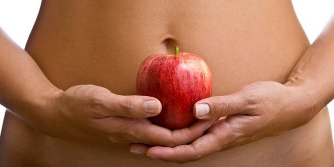 Γυναίκα που κρατά ένα μήλο στα χέρια στο ύψος της μέσης | BMI - Δείκτης Μάζας Σώματος υπολογισμός. Body Mass Index Calculator