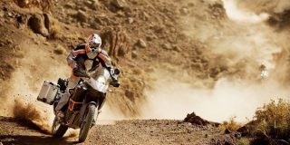 Αναβάτης μοτοσυκλέτας με κατάλληλο κράνος και στολή πάνω σε Moto οδηγεί σε χωμάτινη διαδρομή - δρόμο