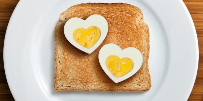 Αυγά πρωινό σε σχήμα καρδιάς πάνω σε φέτα ψωμί τοστ για ερωτευμένα ζευγάρια