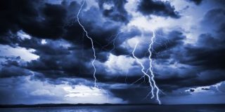 Τοπίο τη νύχτα (θάλασσα και στεριά) που φωτίζετε από την λάμψη αστραπών - κεραυνών κατά τη διάρκεια καταιγίδας