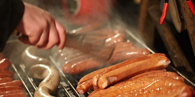 Ψήστης κρατώντας λαβίδα ψήνει λουκάνικα σε ψησταριά με κάρβουνα και αγνοεί (ορθά) τις συμβουλές των γύρων του (Howto DIY)