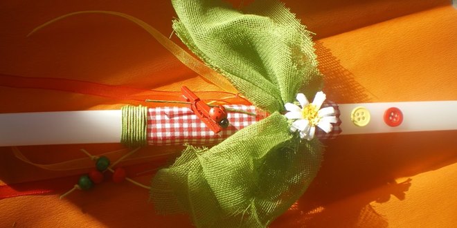 Λαμπάδα από κερί με στολίδια και φιόγκο Πασχαλινό δώρο του Νονού στον βαπτισιμιό του σχετικό με την ασφάλεια πασχαλινών ειδών