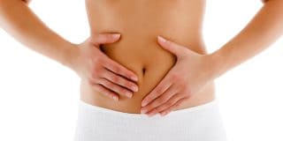 Γυναίκα με πόνο στο στομάχι & στρες. Πώς τα αντιμετωπίζει με υγρά, άσκηση, όχι ερεθιστικές τροφές, θετική σκέψη, συνήθειες