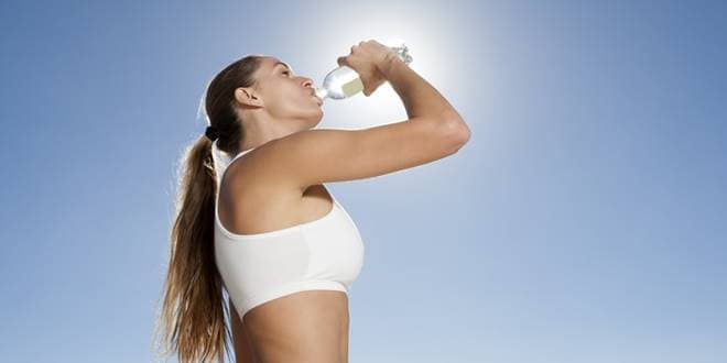 Γυναίκα πίνει αθλητικό ποτό για να έχει τα οφέλη από την κατανάλωση τους