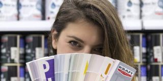 Κοπέλα κρατάει στα χέρια της το χρωματολόγιο της Kraft, με χρώματα για εσωτερικούς και εξωτερικούς χώρους
