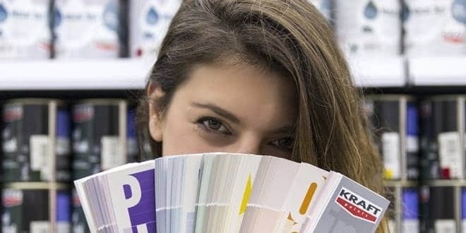 Κοπέλα κρατάει στα χέρια της το χρωματολόγιο της Kraft, με χρώματα για εσωτερικούς και εξωτερικούς χώρους