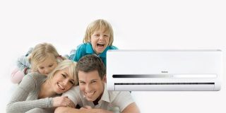 Χαρούμενη οικογένεια (άνδρας, γυναίκα, αγοράκι και κοριτσάκι) ποζάρουν δίπλα σε λευκό κλιματιστικό ψύξης - θέρμανσης