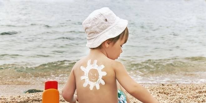 Παιδί στην θάλασσα απολαμβάνει το μπάνιο, προστατευμένο από την Ηλιακή ακτινοβολία ● Δελτίο πρόγνωσης και κλίμακα δείκτη UV