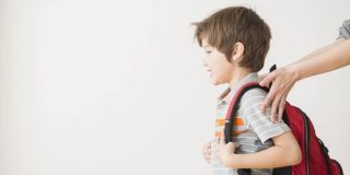 Παιδί σηκώνει την κόκκινη βαριά σχολική του τσάντα - Τι λένε όμως οι παιδίατροι; Πόσα κιλά μπορεί να σηκώνει το παιδί ;