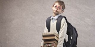 Μαθητής σηκώνει την βαριά του σχολική τσάντα και πολλά βιβλία - Υπολογισμός ιδανικού βάρους της σχολικής τσάντας online