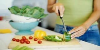 Γυναίκα κόβει πράσινη πιπεριά, ντοματάκια, μαρούλι κλπ ● Χειμερινά λαχανικά για υγεία και καρδιοπροστασία