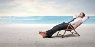 Εργαζόμενος απολαμβάνει ξαπλωμένος στην παραλία την άδεια του | Υπολογισμός άδειας online - Ετήσια άδεια εργαζομένων