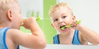 Παιδί βουρτσίζει τα δόντια ακολουθώντας τις 10 συμβουλές για καθαρά και υγιή παιδικά δόντια το καλοκαίρι