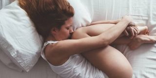 Γυναίκα υποφέρει ξαπλωμένη από πόνους περίοδου - 11 μυστικά για τις «δύσκολες» μέρες της γυναίκας το καλοκαίρι